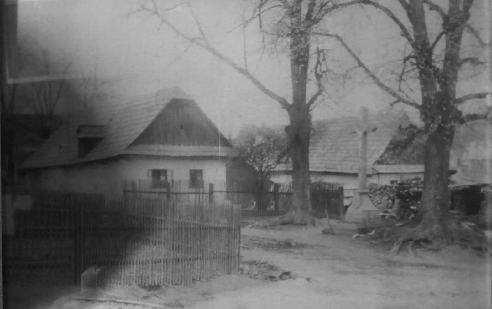 Historická fotografie domů, stromů a pomníku ve Škrdlovicích